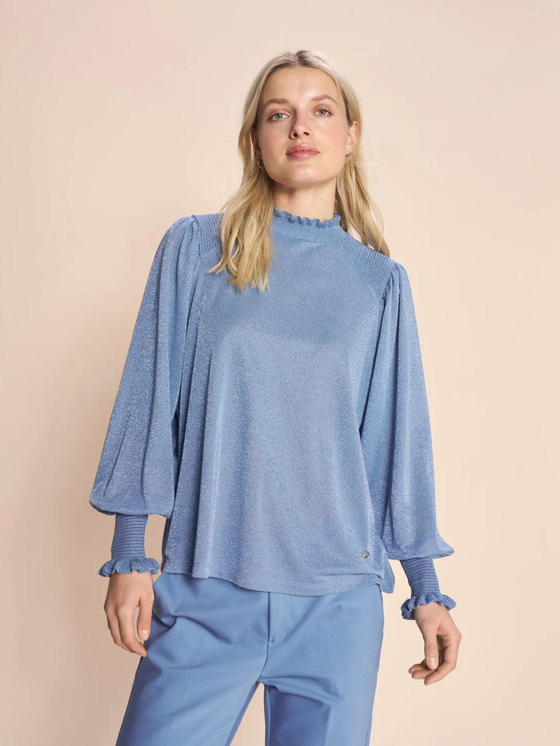 Kaliva blouse in blue This stunning blouse is designed in a regular silhouette and crafted from a viscose-lurex blend. It has ruffles at the neck and billow sleeves ending in cuffs with a smock effect, structured details, and ruffles. 