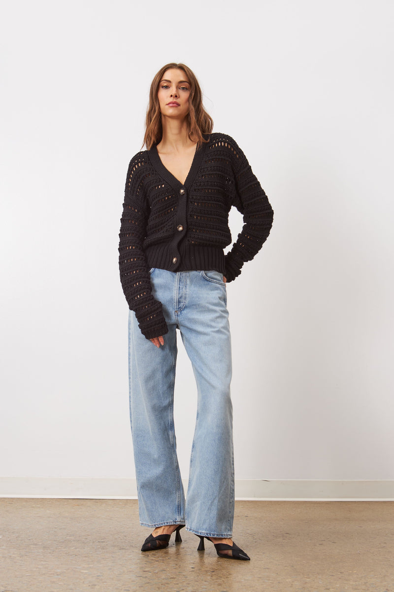 Style Brynne is a cardigan, crafted from a soft cotton yarn, boasts a practical design and features an open work mesh. It can be worn on its own or layered on top of a delicate blouse for a versatile look.

