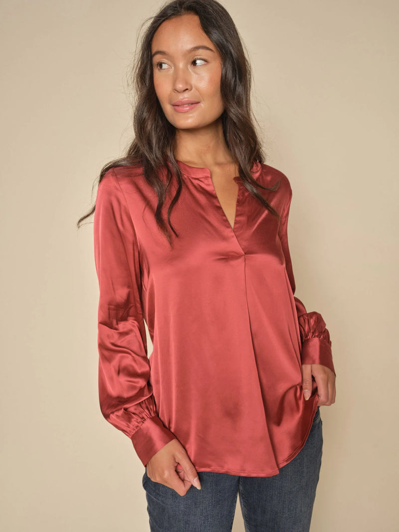 This satin blouse is inspired by the nostalgic 70s. It has a loose silhouette and is designed with a trendy v-neck, billowy sleeves, collar, and buttoned cuffs. We think it looks amazing with everything from tailoring to skirts and jeans.